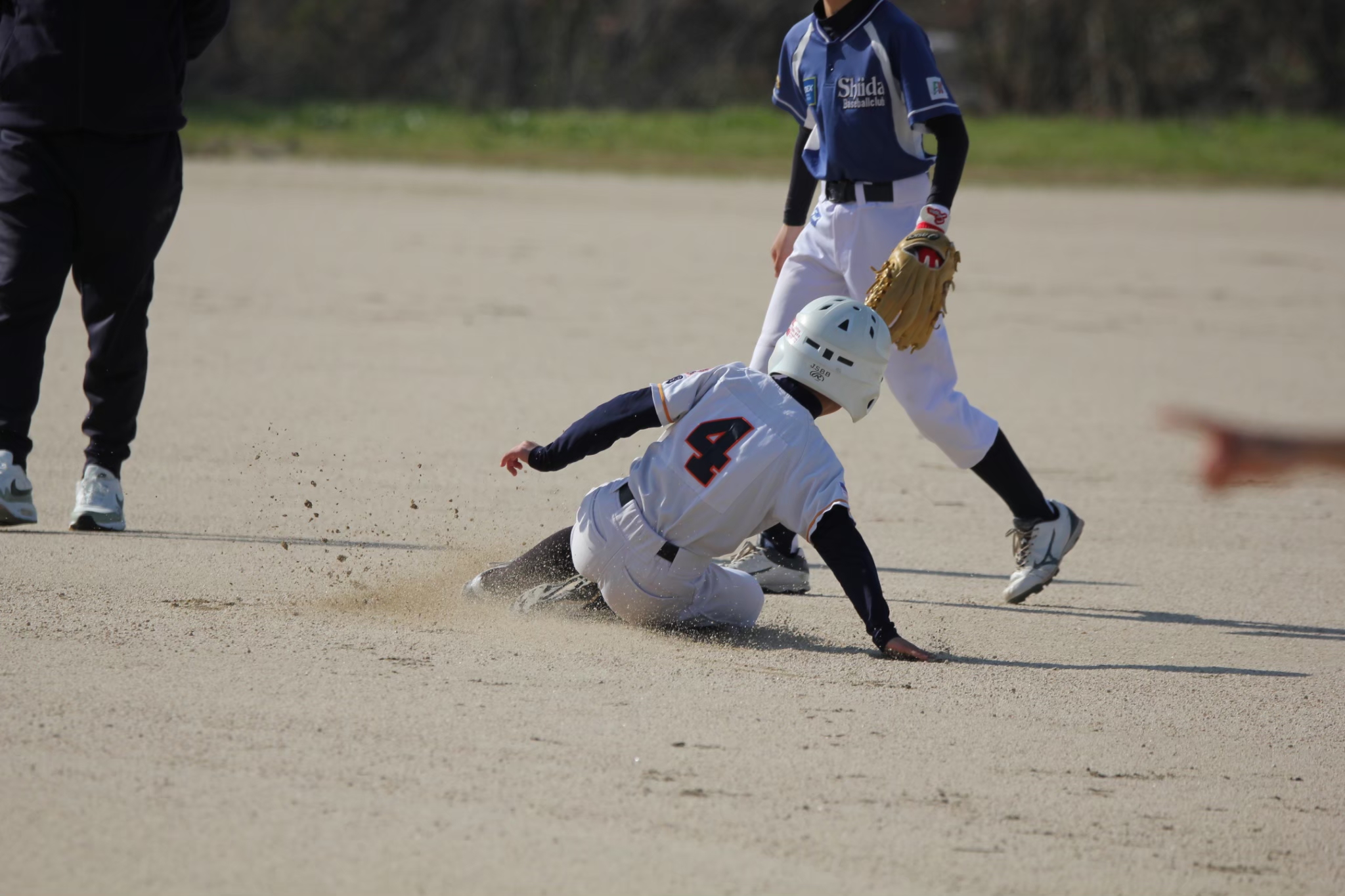 スライディングで盗塁する選手（行橋少年野球団）